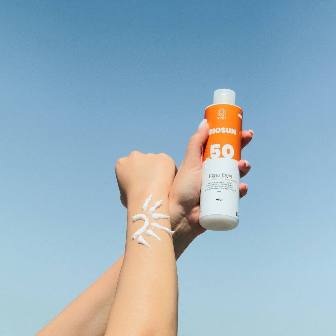Person holding a bottle of sunscreen